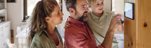 Family looking at smart thermostat